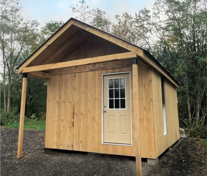 Z Rustic wooden bridal cabin at Riverbend Events venue, surrounded by trees, offering private and comfortable accommodations for wedding parties and newlyweds as part of all-inclusive wedding packages.