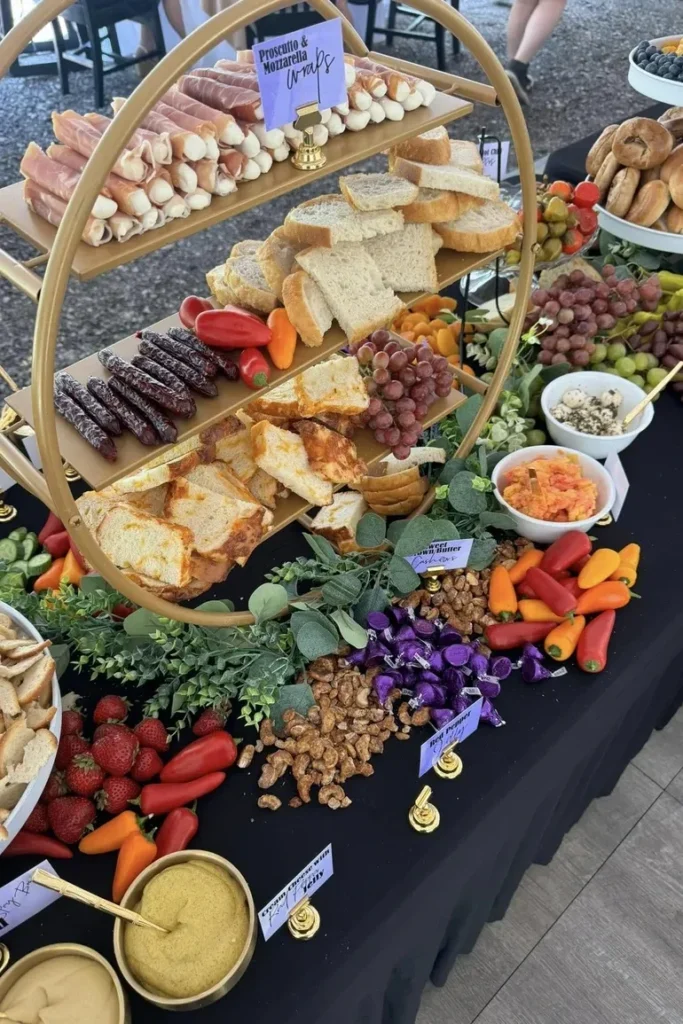 Elegant wedding charcuterie display featuring prosciutto and mozzarella wraps, assorted breads, grapes, nuts, fresh vegetables, and spreads on a decorated table for special occasions.